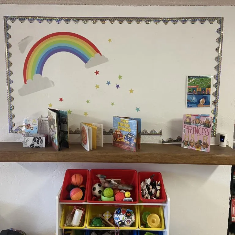 Louisville clinic playroom with a rainbow mural, books and toy bins