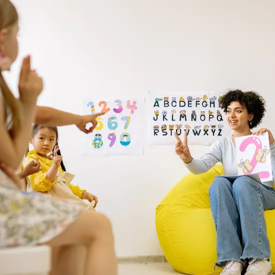 A clinician working with two children at a whiteboard