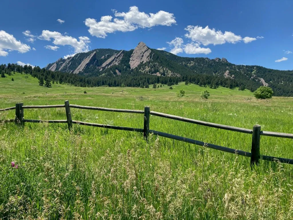 Wooden fence in a grassy open space with mountains near Boulder, Colorado, a quiet low-sensory spot