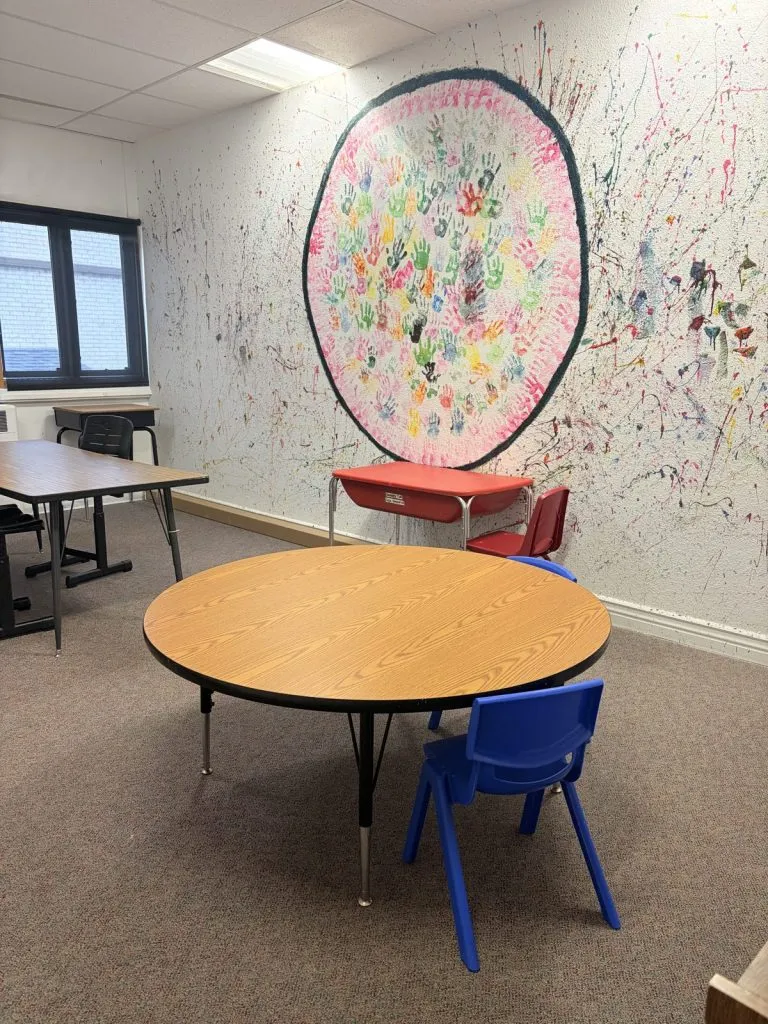 Florence clinic: therapy room with a handprint mural and round table